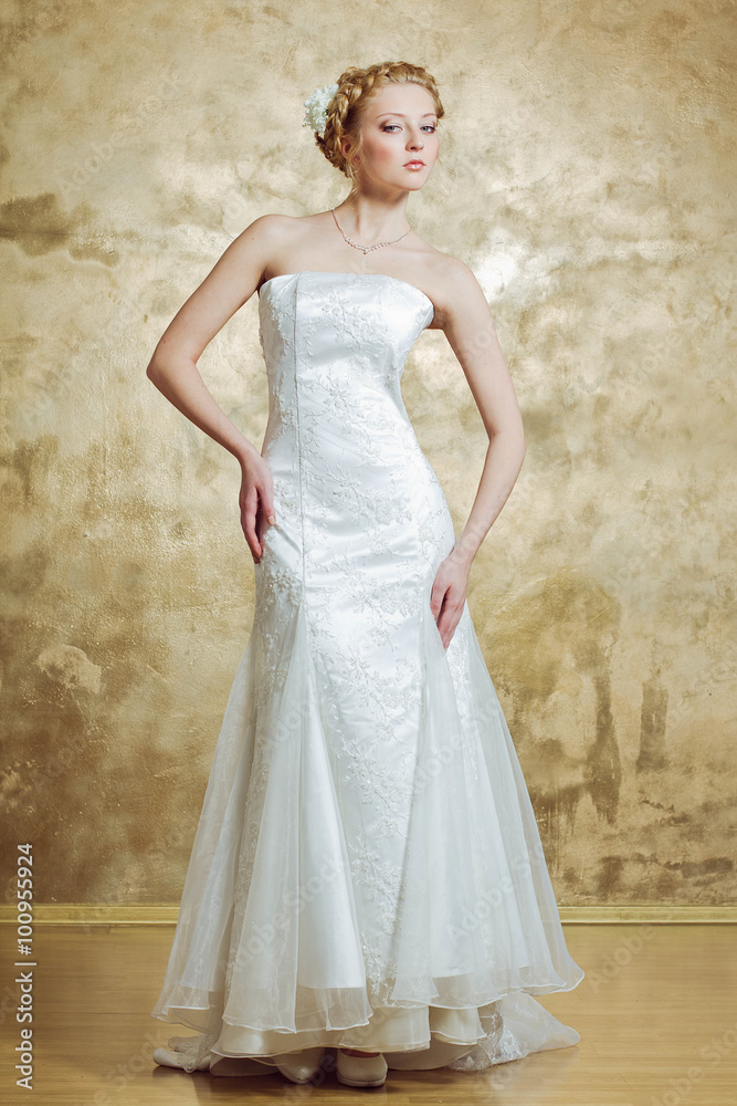 Woman in Weddind dress posing on gold background Woman in Weddind dress posing on gold background