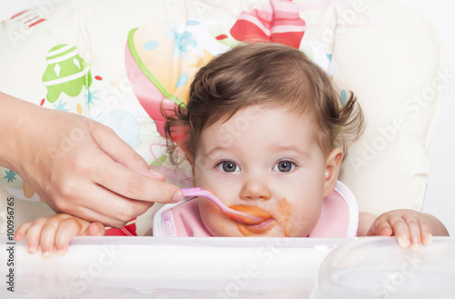 Obraz na plátně Feeding adorable smudgy baby and favorite baby food