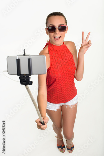 Girl showing piece sign taking selfie.