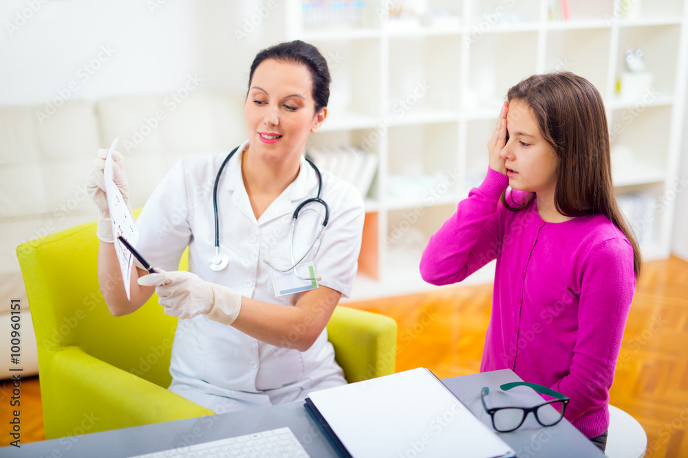 Female pediatrician pointing at eye chart to child