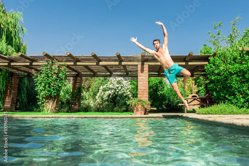 Young man jumping into the pool