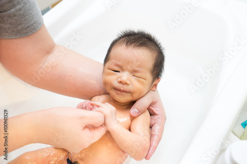 Asian newborn baby having a bath