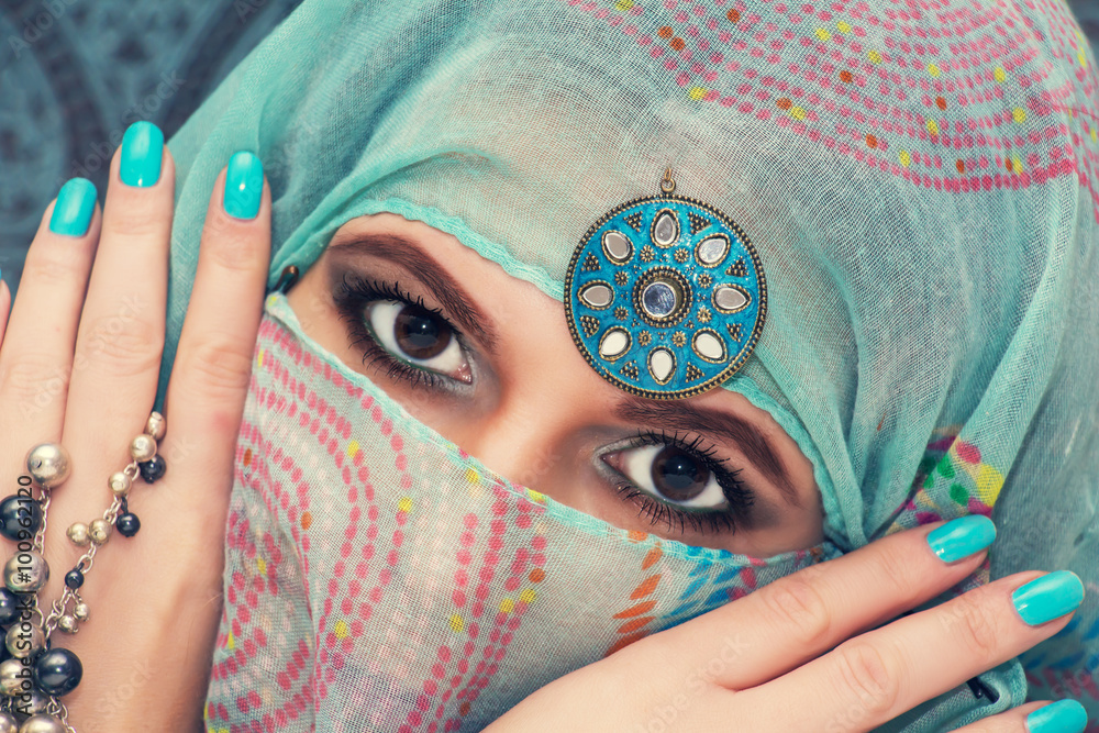 Fototapeta premium Portrait of a beautiful oriental woman in a traditional headscar