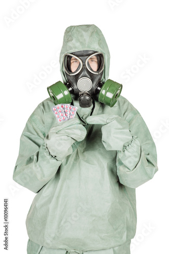 Man with protective mask and protective clothes holding out pill