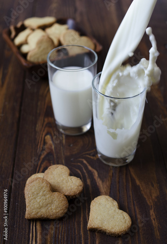 Pouring milk with cookies in the shape of a heart 