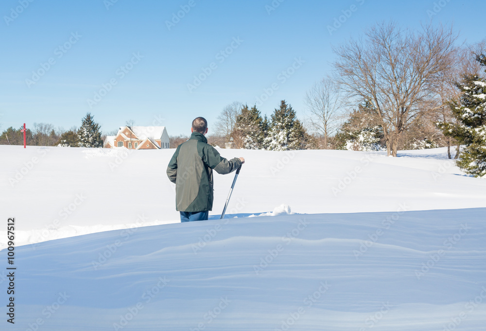 Senior adult man trying to dig out drive in snow