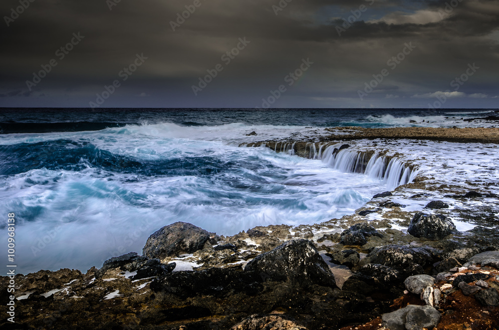 A windy day near the coast where the waves were creating small waterfalls. Crete-Greece.