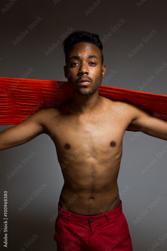 Fototapeta premium Latin man posing indoor over a grey wall.