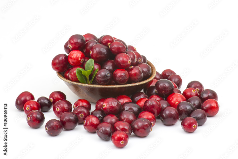 Cranberries in wooden bowl on white background.