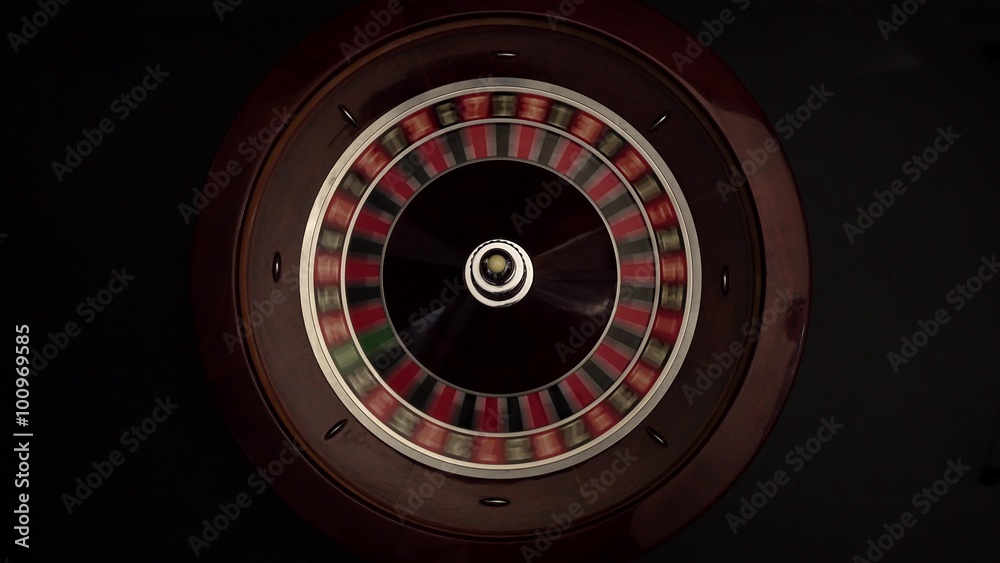 Classic roulette spinning wheel, white ball, on black Classic roulette spinning wheel, white ball, on black