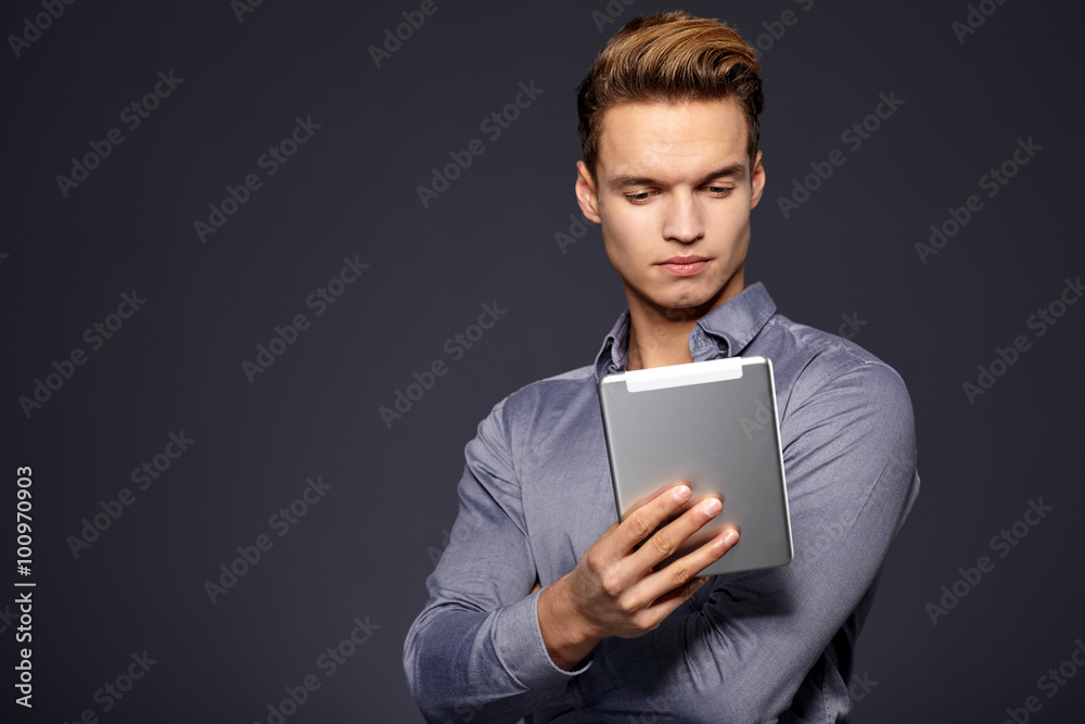 Businessman using a tablet computer - isolated over a grey backg Businessman using a tablet computer - isolated over a grey backg