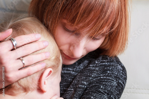 Mother cuddles her son