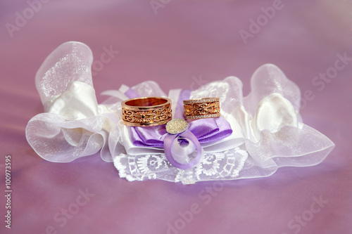 wedding rings lie on beautifully embellished fabrics photo