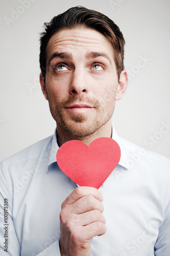 Valentine's Day. Emotions. Portrait of a man with a red heart in