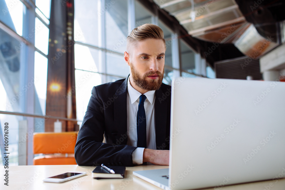 Focused businessman working on laptop in the office Focused businessman working on laptop in the office