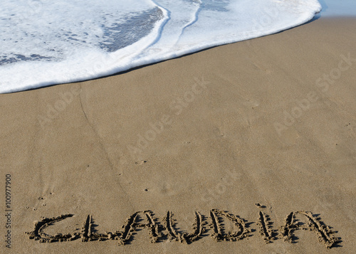 Nombre de Claudia escrito en la arena