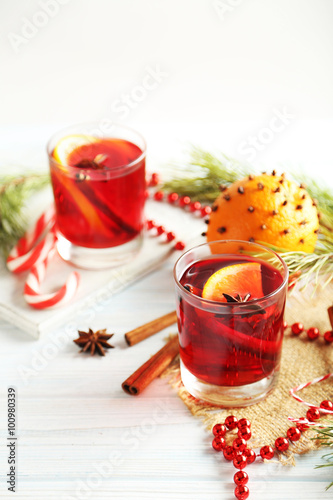 Mulled wine in glass on white wooden table