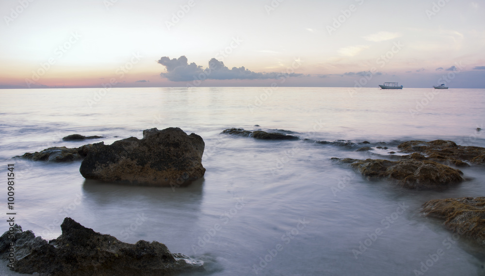 rocky ocean coastline during sunset with blur motion effect