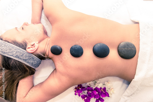 Woman having massage with hot stones