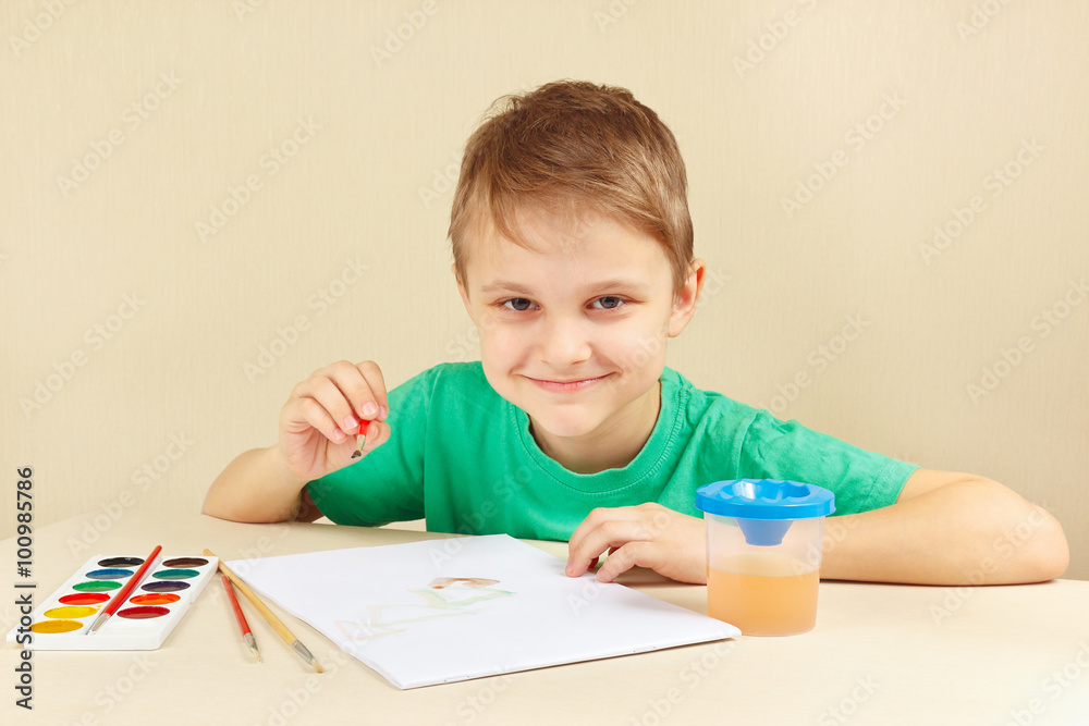 Young artist in a green shirt painting with watercolors Young artist in a green shirt painting with watercolors