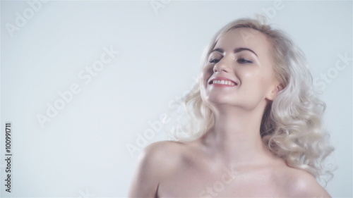 Beautiful young blonde woman having a idea. Portrait of a sensual young blond woman with bare shoulders isolated on white background.