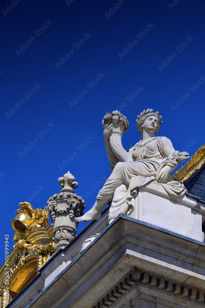 Beautiful roof details with golden ornaments and statues of Palace of Versailles