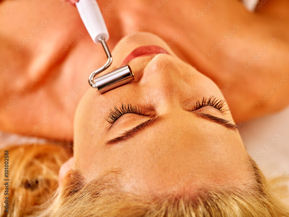 Φωτογραφία Young woman with closed eyes receiving electric galvanic face spa massage at beauty salon
