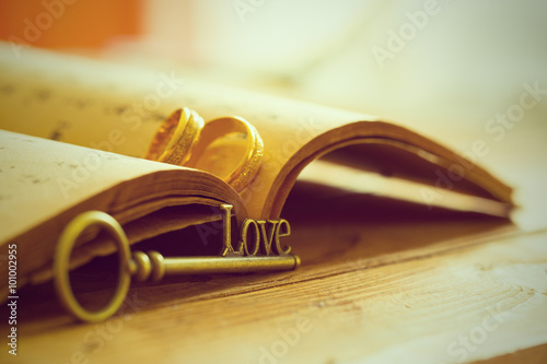 Love and Romance vintage concept with engagement ring and love shape key placing on book on a table