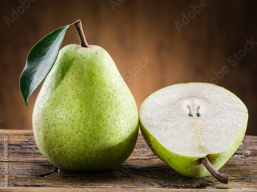 Pear fruit with leaf on wooden background.