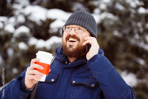 Happy bearded hipster man in glasses with cup of hot coffee  photo