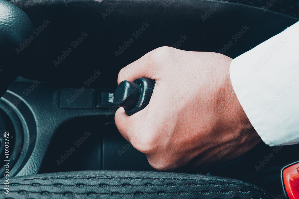 business man holding handbreak in car.