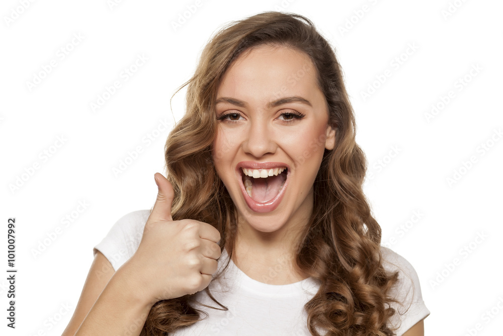 beautiful smiling girl showing thumbs up on a white background beautiful smiling girl showing thumbs up on a white background