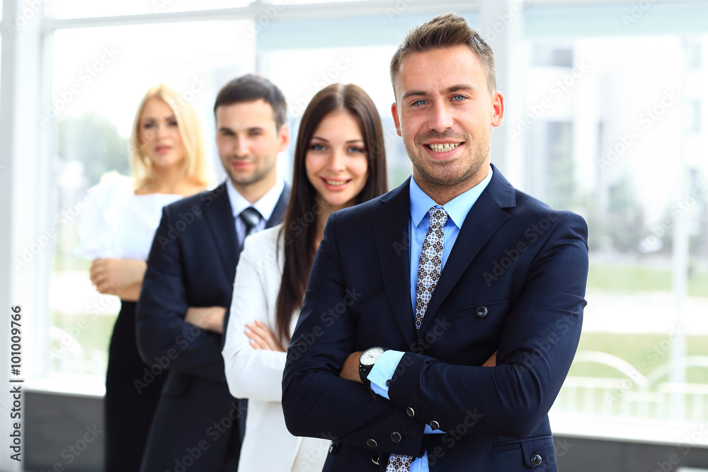 Group of friendly businesspeople with male leader in front Group of friendly businesspeople with male leader in front