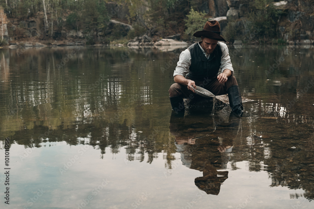 unshaved golddigger washes gold in the lake with rocky bank unshaved golddigger washes gold in the lake with rocky bank