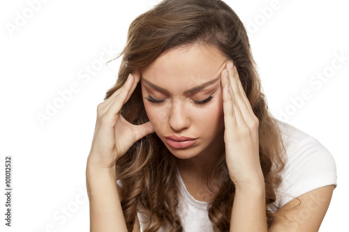 pretty girl with a strong headache on a white background