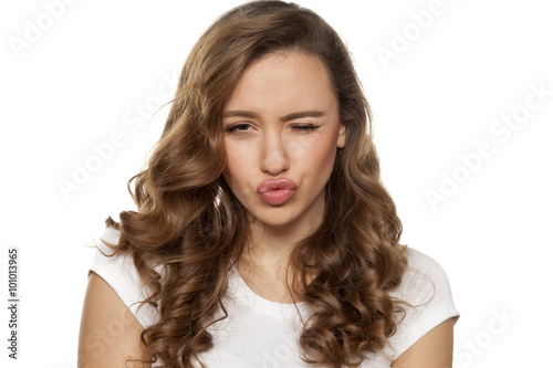 Photography winking beautiful young woman with pursed lips