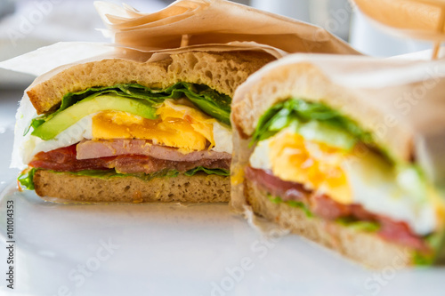 Sandwich with egg, ham, avocado in restaurant