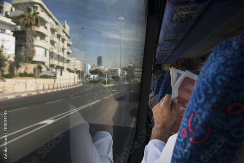 Israel. Jewish man reading newspaper going by bus.