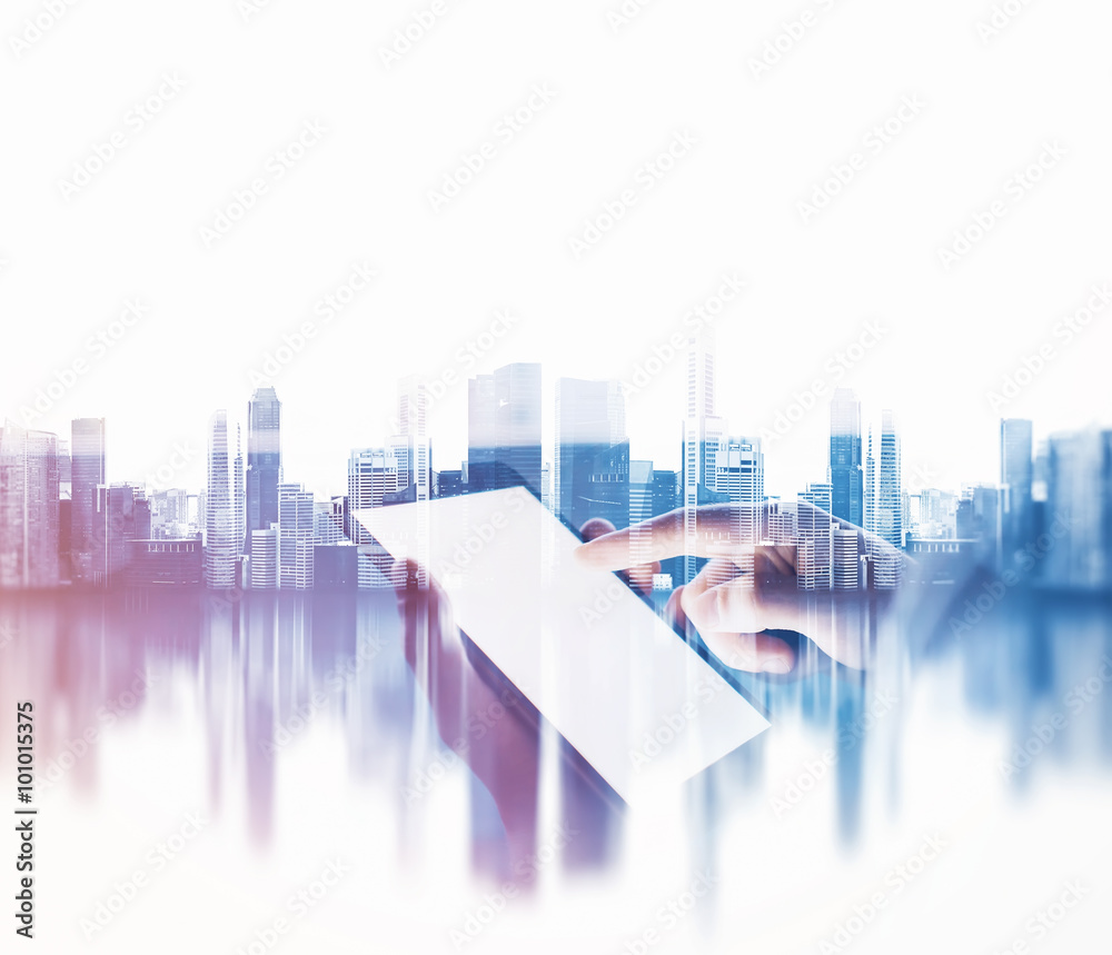 Female hand touching screen of her phablet, blurred city background. Double exposure.