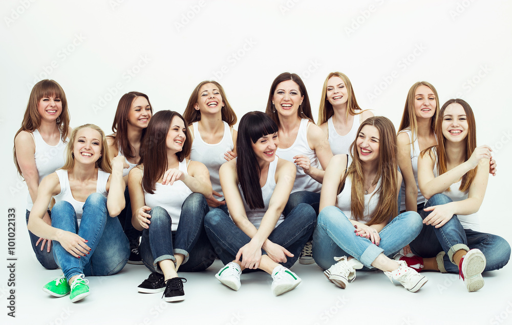 Happy together concept. Group portrait of healthy girls in white t-shirts  and blue jeans sitting and posing over white background. Copy-space. Urban  style. Studio shot Photos | Adobe Stock