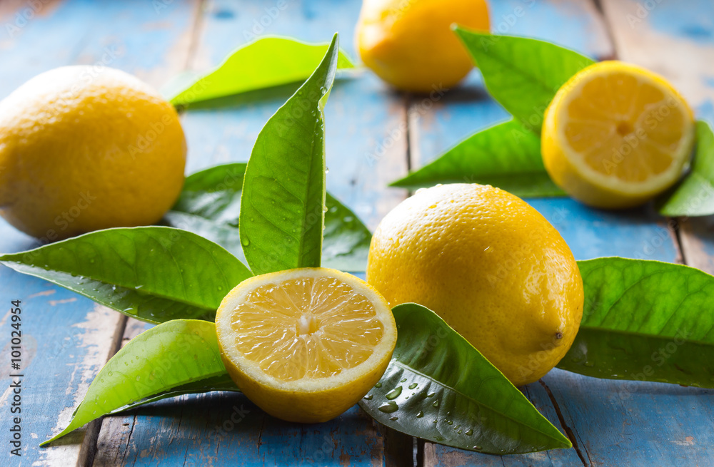 Fresh lemons with leaves on old wooden blue background Fresh lemons with leaves on old wooden blue background