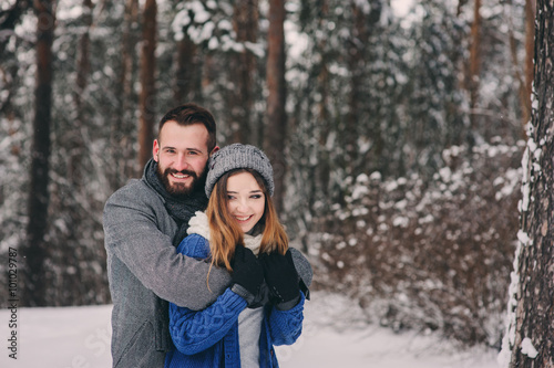 happy loving couple walking in snowy winter forest, spending christmas vacation together. Outdoor seasonal activities. Lifestyle capture. © mashiki