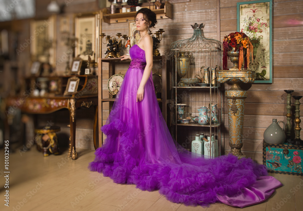Fototapeta premium Beautiful woman dressed in long lace dress in a vintage interio