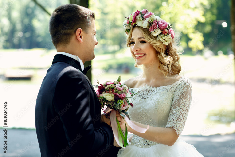 Handsome happy groom and smiling bride in elegant white dress in Handsome happy groom and smiling bride in elegant white dress in