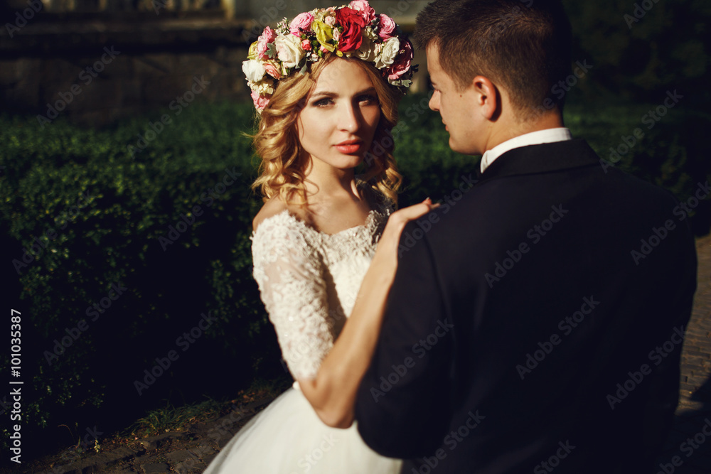Handsome romantic groom looking at beautiful blonde bride with b