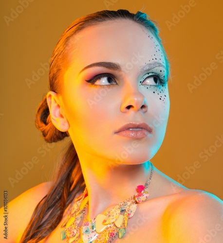 supermodel with creative makeup. in the studio on a yellow background