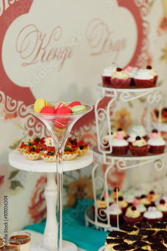 Delicious and tasty wedding dessert table with cupcakes and pies
