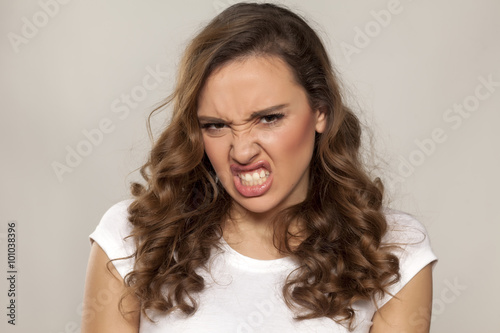 angry and mad pretty girl on a gray background