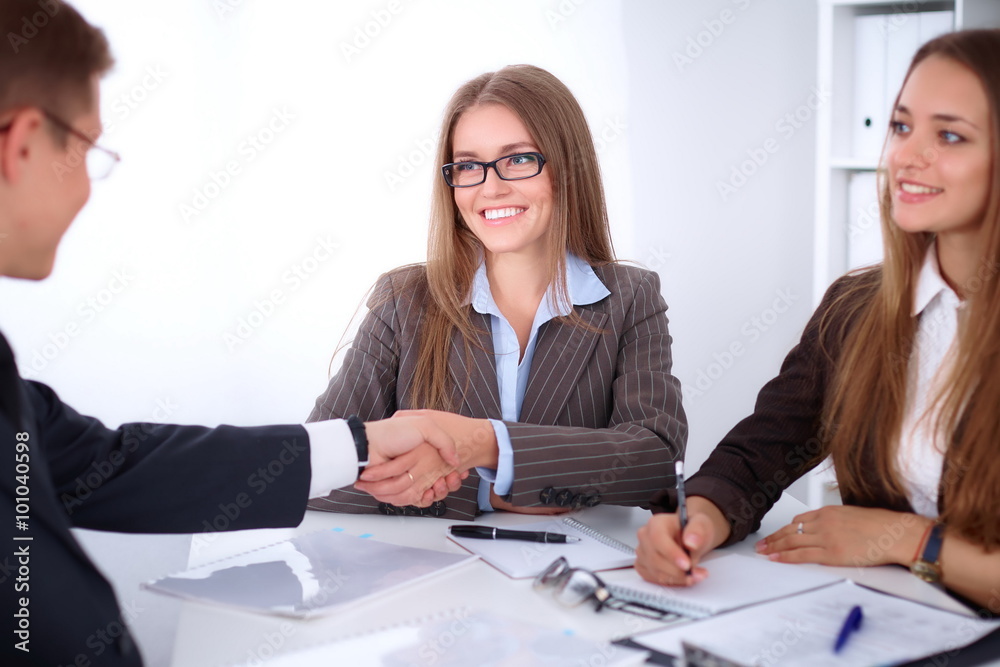 Business handshak sitting at the desk on office background, copy space area at the left upper corner Business handshak sitting at the desk on office background, copy space area at the left upper corner