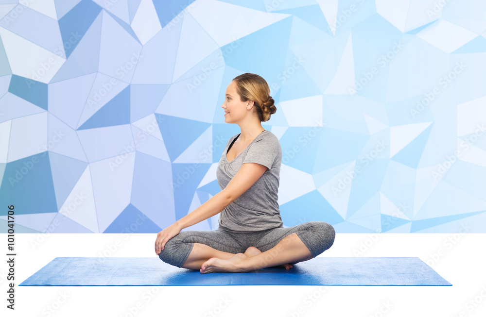 woman making yoga in twist pose on mat woman making yoga in twist pose on mat